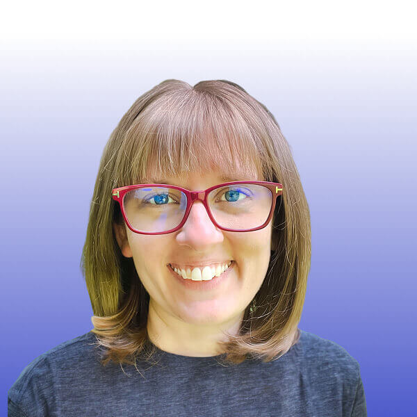 Portrait of Portrait of Jillian Bejtlich, a smiling person with shoulder-length brown hair and red glasses, wearing a dark shirt, in front of a gradient background fading from white at the top to blue at the bottom.