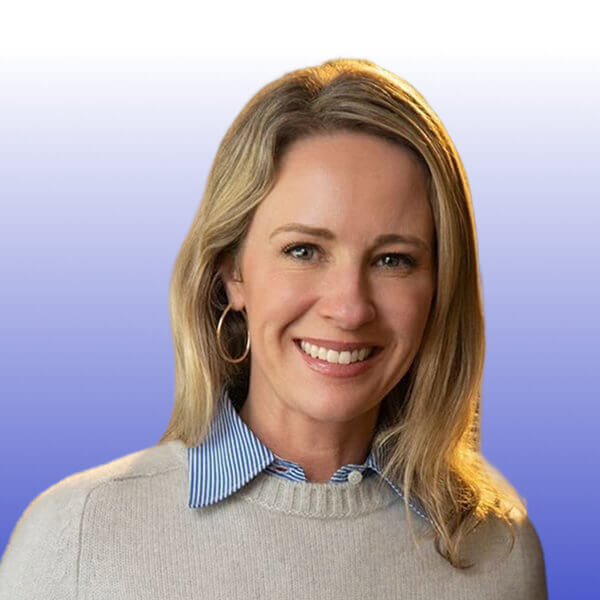 Portrait of Marilee Bear, a woman with blonde hair wearing a light gray sweater over a blue and white striped collared shirt, smiling in front of a gradient blue and white background at Gainsight Pulse.